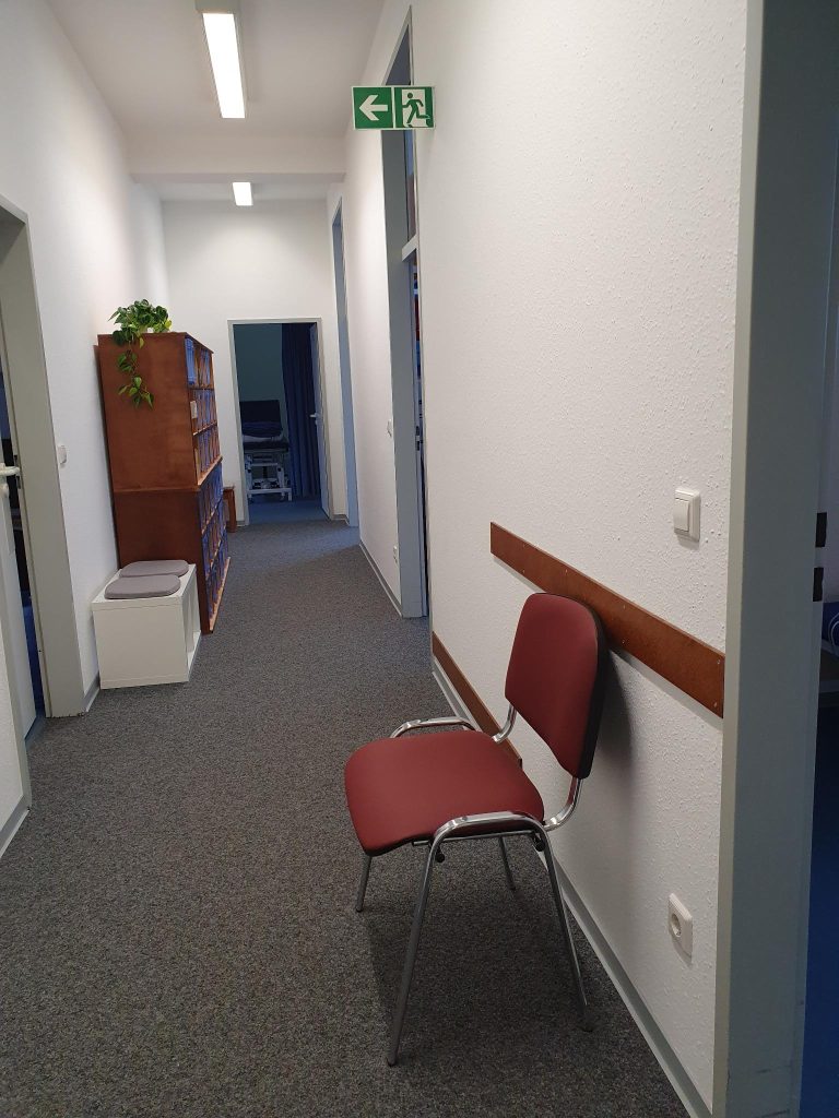 Praxis Flur mit Sitzgelegenheiten und Türen zu Behandlungszimmern